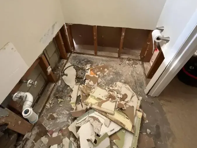 Bathroom wall framing exposed during sewage cleanup