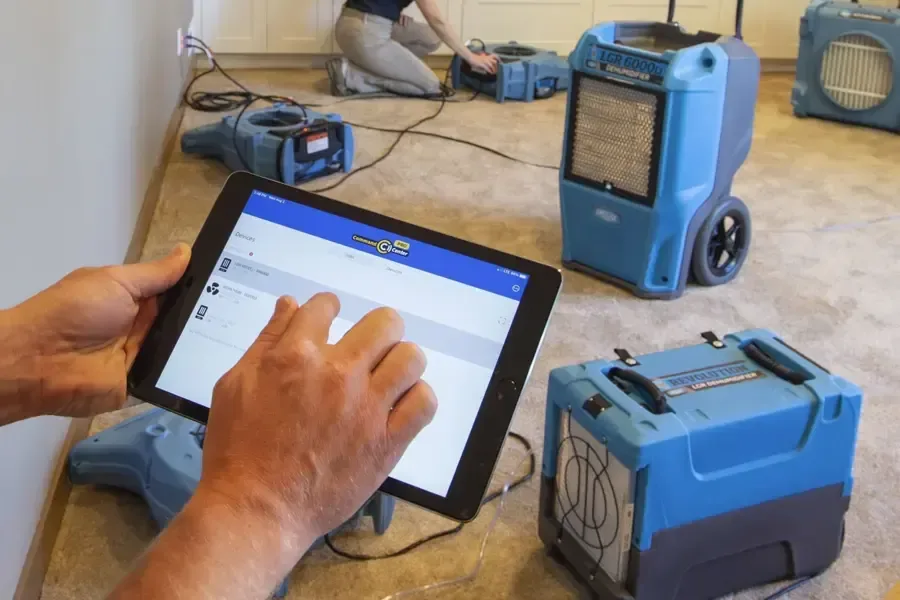 Moisture records on a tablet beside drying equipment