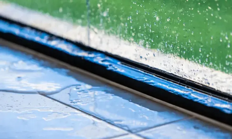 Rainwater pooling along the inside of a window frame