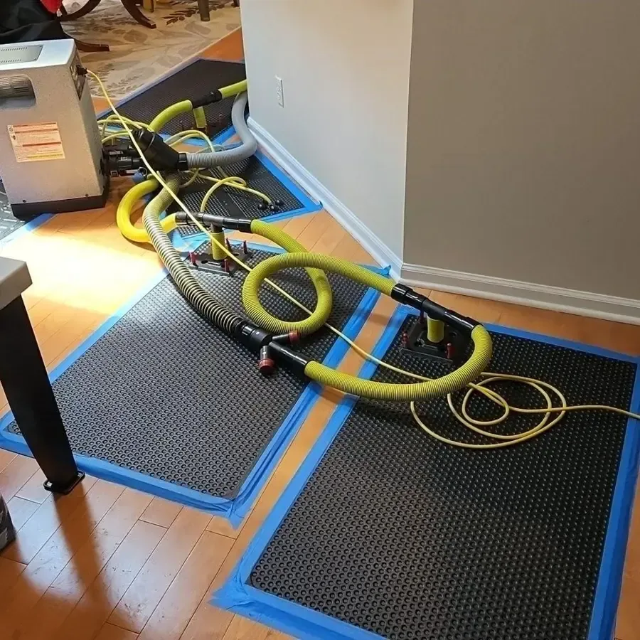 Drying mats and yellow hoses cover a wood floor